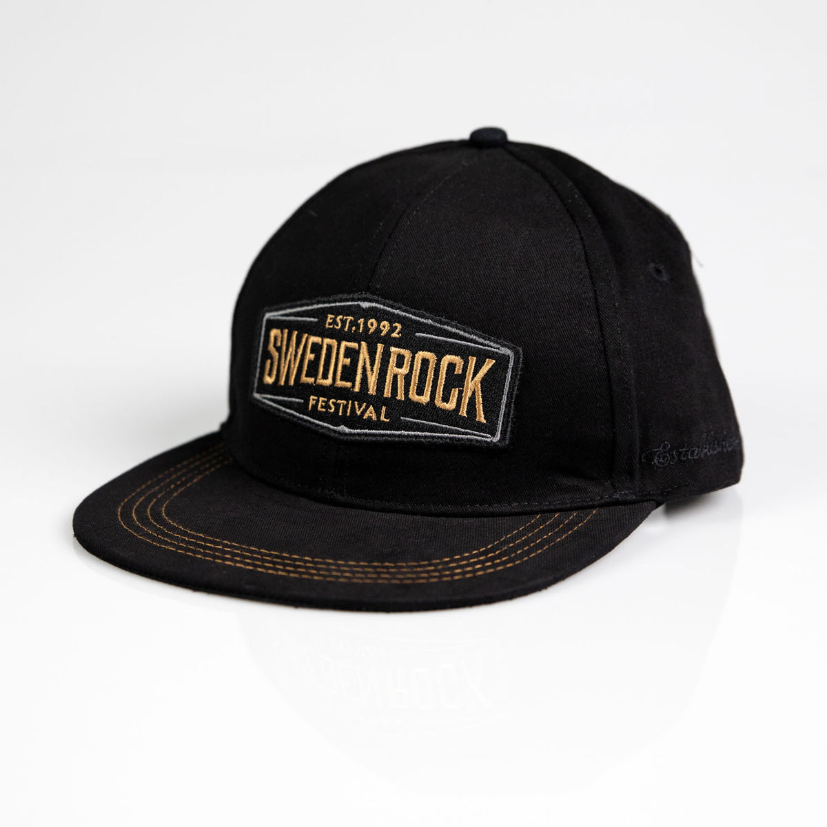 Keps Snapback Black & Gold har gul broderad "Sweden Rock Festival Est. 1992" text på framsidan, en rak skärm med synliga gula sömmar och visas på en vit bakgrund.