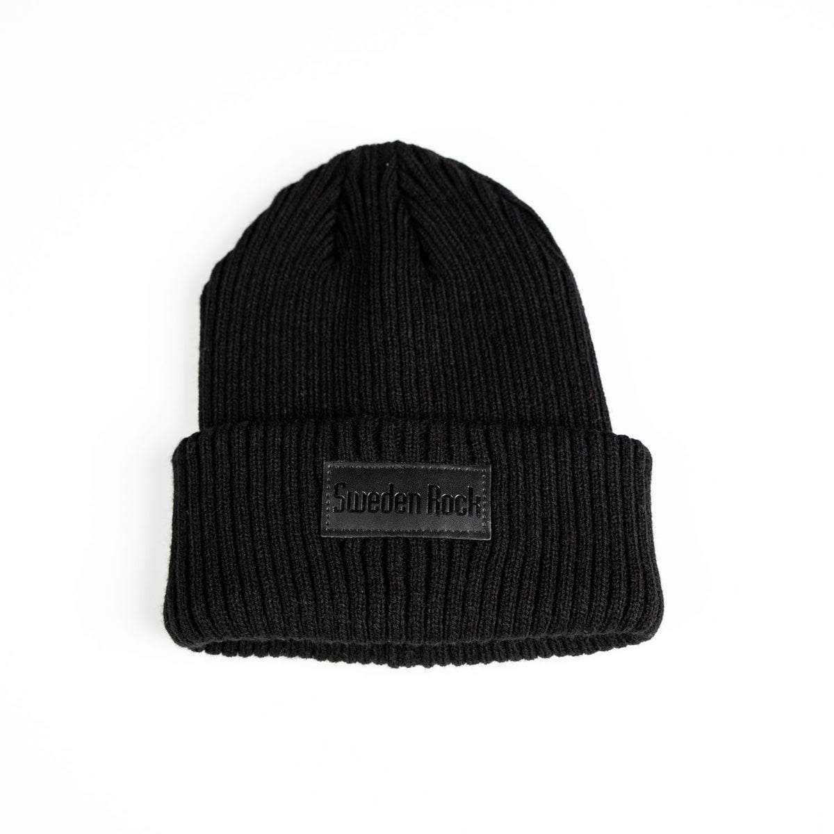 Beanie är en svart ribbstickad mössa tillverkad av mjuk akryl, med vikt skärm och en rektangulär Sweden Rock-patch på framsidan, mot en vit bakgrund.