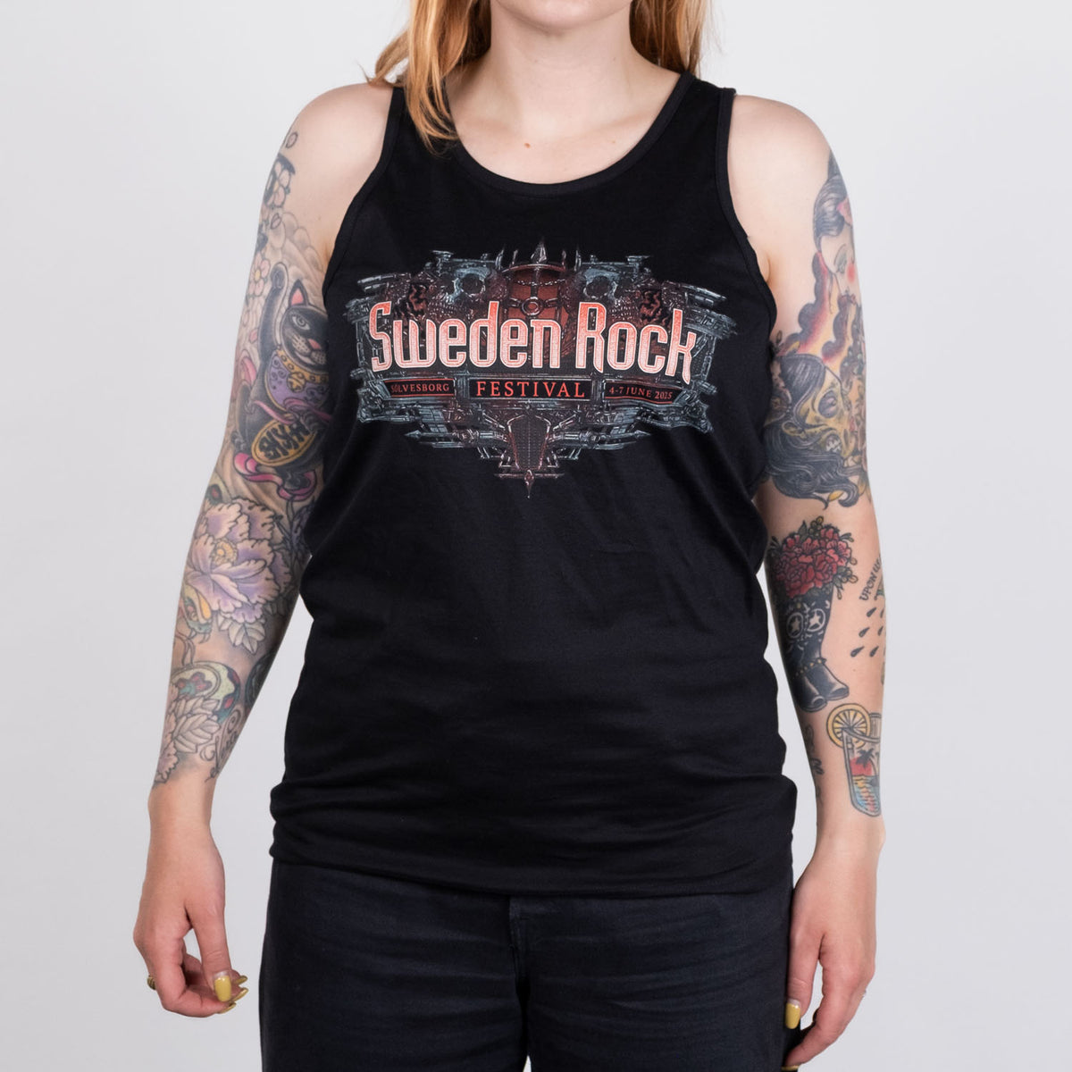 En person med tatuerade armar bär Festival Tank Top, en svart tröja i 100% bomull med texten "Sweden Rock Festival". På bilden syns endast överkropp och överarmar mot en ljus bakgrund.