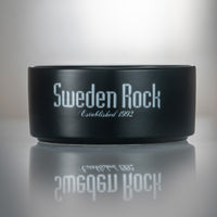Skål - en svart keramikskål med texten "Sweden Rock Established 1992" i silver på sidan, visad mot ljus bakgrund med spegling under.