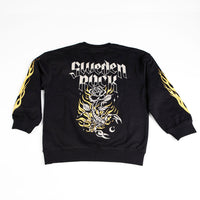 Sweater Scorpion är en svart sweatshirt tillverkad av ekologisk bomull med "Sweden Rock" i gotiska bokstäver på ryggen, som visar en stor ros, taggar och flammor. Gula flammor flammar längs båda ärmarna.